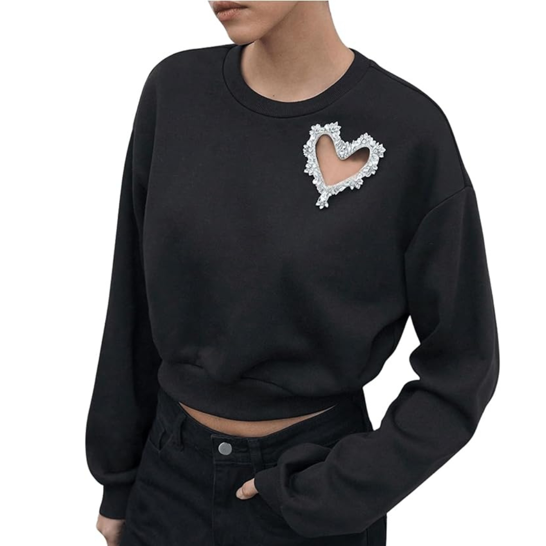 A woman wearing a black sweatshirt with a rhinestone heart cut-out.